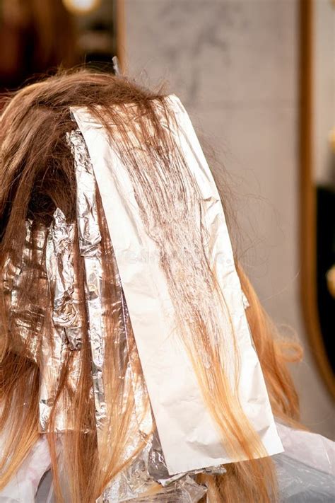 Beautiful Young Caucasian Woman With Foil In Her Hair While Dyeing Her