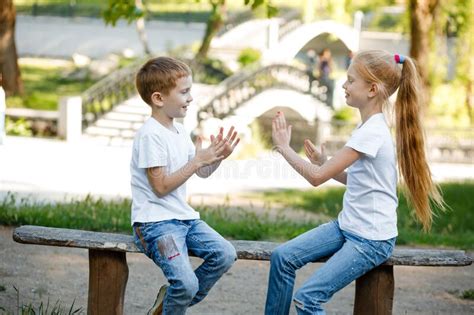 Cheerful Children Are Playing In The Park On A Green Bench Stock Image