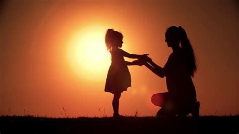 Silhouette Of Mother And Little Daughter Having Fun Playing At Sunset