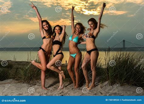 Group Of Four Models Wearing Bikinis Posing At Sunset Beach Stock Photography Cartoondealer