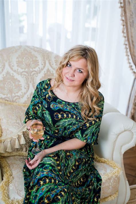 Woman Sitting On An Armchair And Having A Glass Of Wine Stock Photo