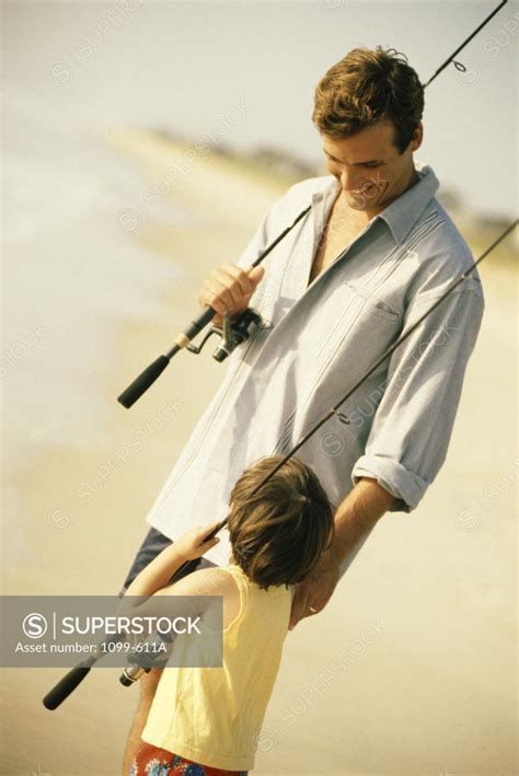 Father And His Son Holding Fishing Rods Superstock