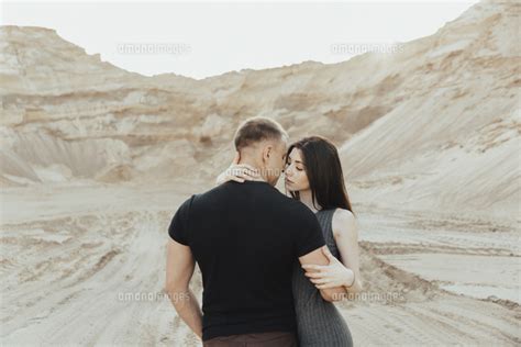 middle eastern couple hugging in desert[11018101963]の写真素材・イラスト素材｜アマナイメージズ