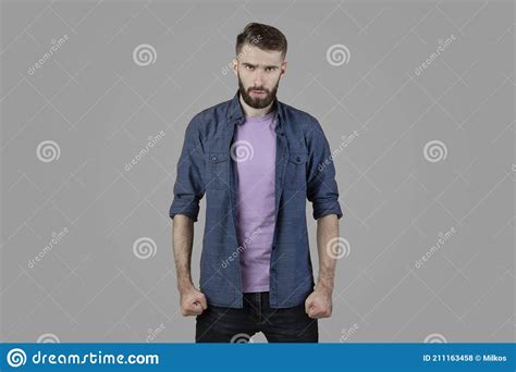 Furious Young Man Clenching His Fists Suppressing His Anger On Grey