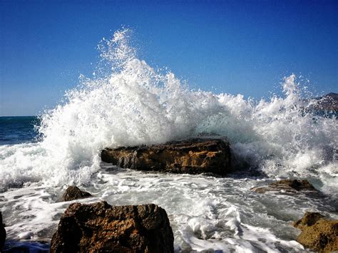 Rocky Seashore With Ocean Wave Under Blue Sky · Free Stock Photo
