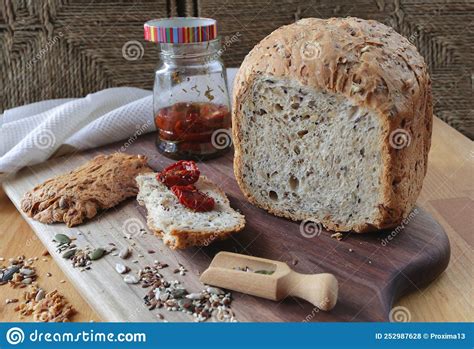 Loaf Of Homemade Whole Grain Bread And A Cut Slice Of Bread On A Wooden