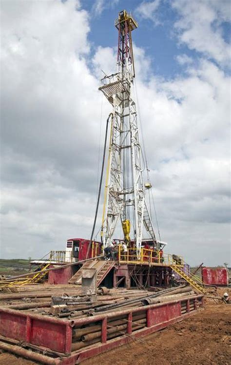 Oilfield Workers With Bramwell Petroleum Set Up A Drilling Derrick For