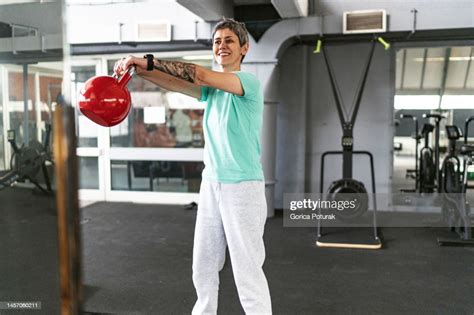 Mature Woman In Gym Working Out Using Kettlebells High Res Stock Photo