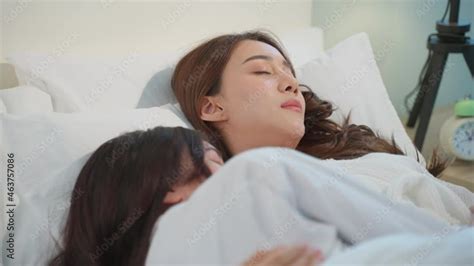 asian beautiful lesbian couple lying down on bed and hugging each other stock ビデオ adobe stock