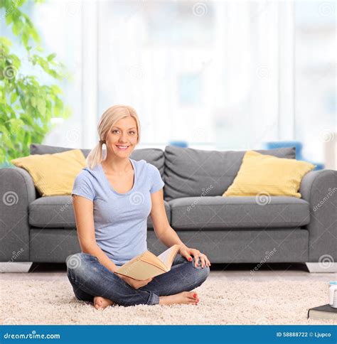 Woman Sitting In Front Of A Sofa And Holding Book Stock Photo Image