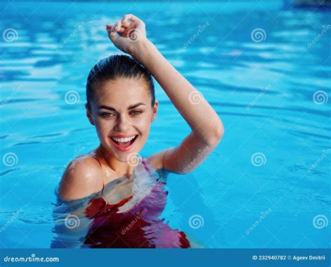Woman In Red Swimsuit In The Pool Holds Her Hands Above Her Head Luxury Relaxation Stock Photo