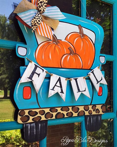 A Blue Truck With Pumpkins On The Front And Banner Hanging From Its Side