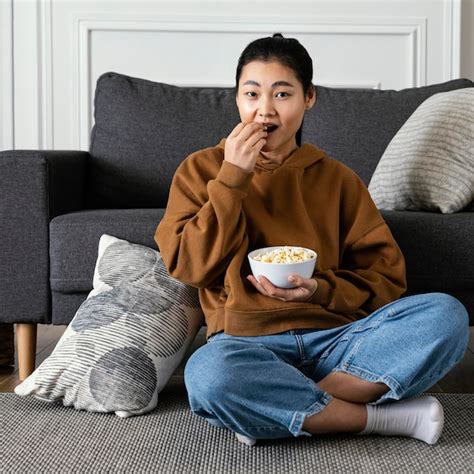 Free Photo Woman Watching Tv And Eating Popcorn