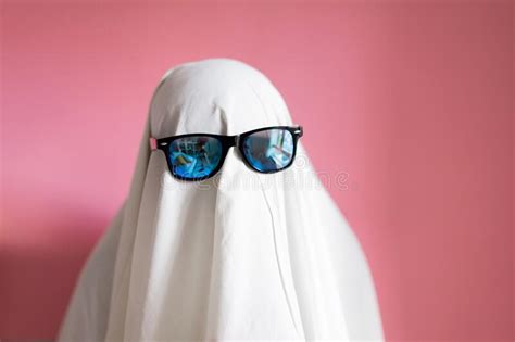 Scared Sheet Costume Ghost With Sunglasses Hugging His Pillow On A Pink