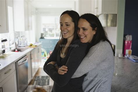 happy lesbian couple embracing at home[11100071901]の写真素材・イラスト素材｜アマナイメージズ