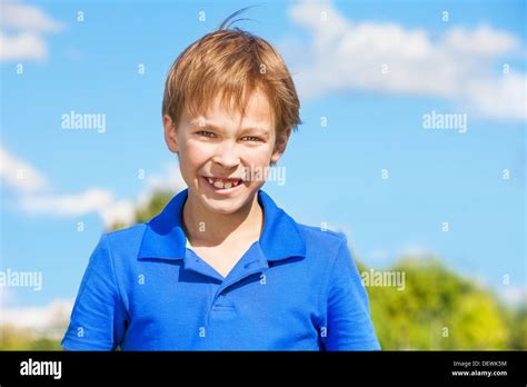 Happy Smiling Eight Years Old Caucasian Boy In Blue Shier With Sky On