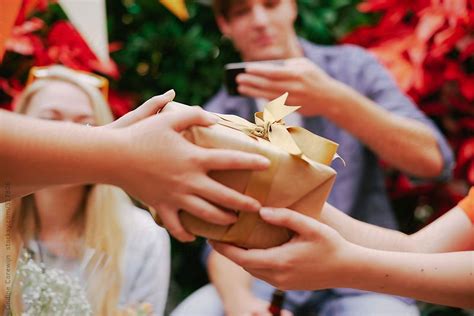 Friends Handing Over Ts At A Birthday Party By Stocksy Contributor