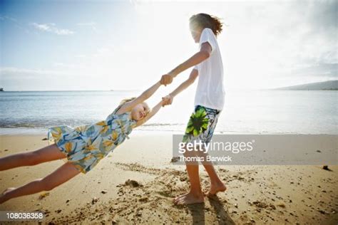 Brother Spinning Little Sister By The Arms Photo Getty Images