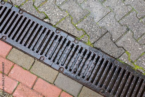 Wet Storm Sewer Grate On The Border Of The Pedestrian Zone During Rain Stock Photo Adobe Stock