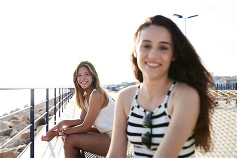Smiling Girlfriends On Pier By Stocksy Contributor Guille Faingold Stocksy