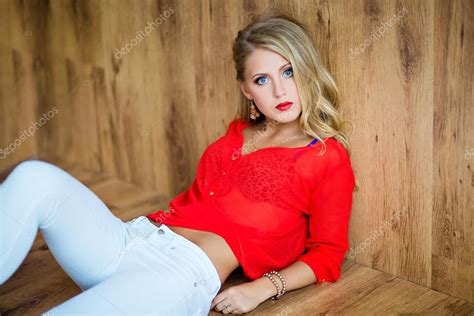 Beautiful Sexy Blonde Girl In A Red Blouse Lying On The Floor Stock