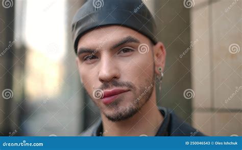 headshot of confident gay man biting lower lip looking at camera and looking around close up