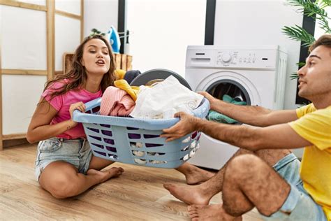 Man And Woman Couple Pulling Laundry Basket At Laundry Room Stock Image