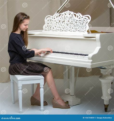 A Teenage Girl Is Playing On A White Grand Piano Stock Image Image