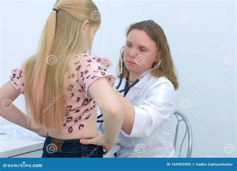 Pediatrician Woman Listening To Heartbeat Of Girl Using Stethoscope In