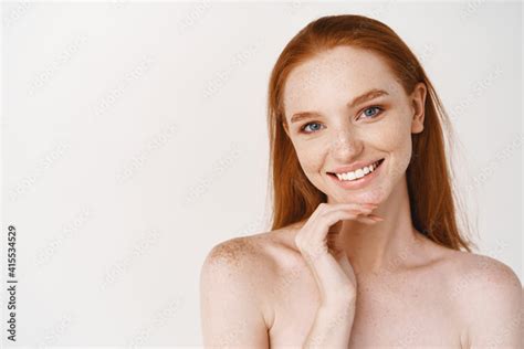 Close Up Of Beautiful Redhead Woman With Pale Skin Standing Nude On White Background Smiling