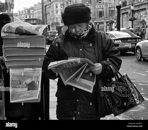 black and white photograph of a woman reading the evening standard in regent street london