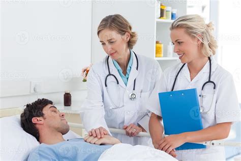 Two Women Doctors Taking Care Of A Patient Stock Photo At Vecteezy