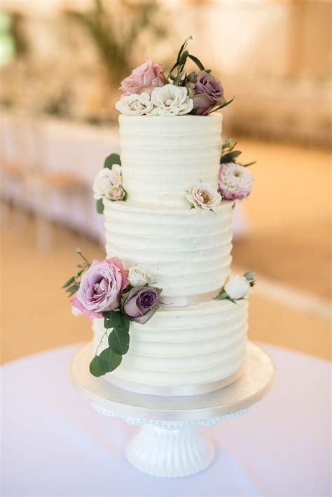 three tier buttercream wedding cake with real flowers image by emma hare photography wedding