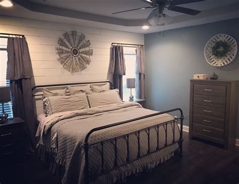 Shop gift ideas for mom. Farmhouse bedroom with faux shiplap, wrought iron bed ...
