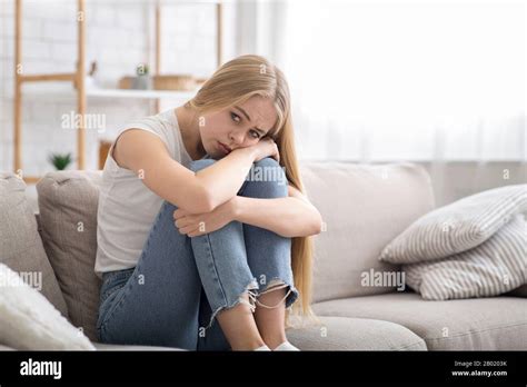 Lonely Sad Girl Sitting On Couch At Home Alone Stock Photo Alamy