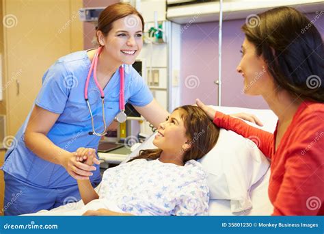 Mother And Daughter Talking To Female Nurse In Hospital Room Stock