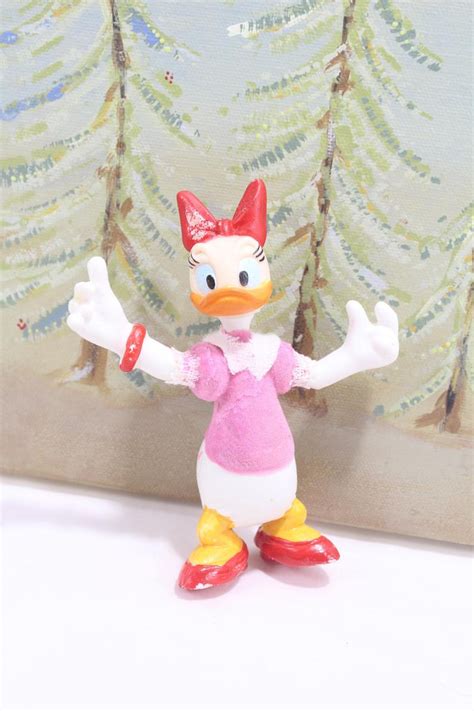 A Toy Duck Wearing A Pink Dress And Red Shoes Standing In Front Of A