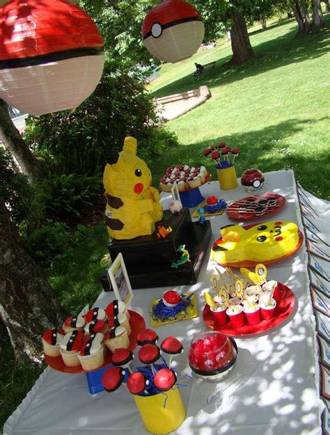 A Table Topped With Lots Of Cupcakes And Cake Next To A Pokemon Pikachu