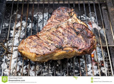 The larger side is strip steak, and the. Whole T-Bone Steak Cooking On Grill Stock Photo - Image of ...