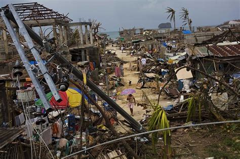 Typhoon Haiyan Survivors Walk Through Ruins In The Village Of Maraboth