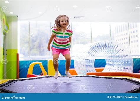 Niño Saltando En Trampolín Patio De Juegos De Colores Imagen De Archivo