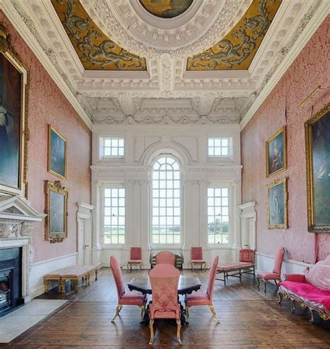 A Large Room With Pink Chairs And Paintings On The Walls Along With A