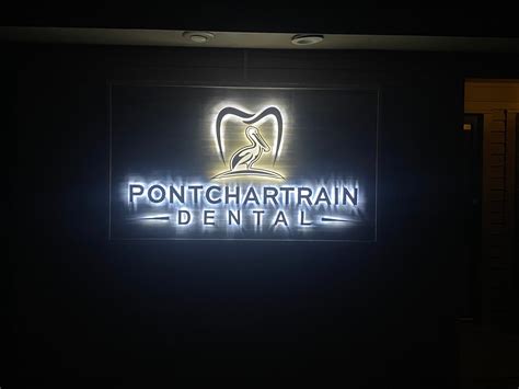 a lighted sign for a dental office in the dark