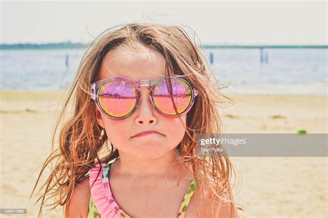 Young Girl At The Beach Wearing Sunglasses Photo Getty Images