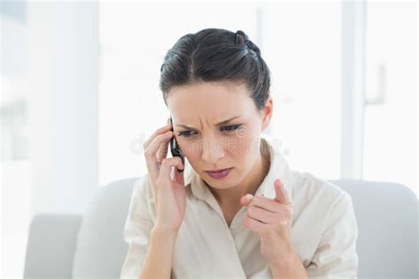 Frowning Stylish Brunette Businesswoman Making A Phone Call Stock Photo