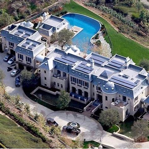 An Aerial View Of A Large Mansion With A Swimming Pool In The Middle Of It