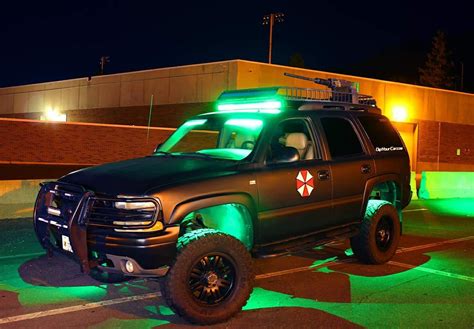 A Truck With Lights On It Parked In A Parking Lot Next To A Building At