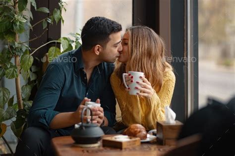 Young Couple In Love Sitting In A Cafe Drinking Coffee Kissing Couples Couples Coffee Drinks