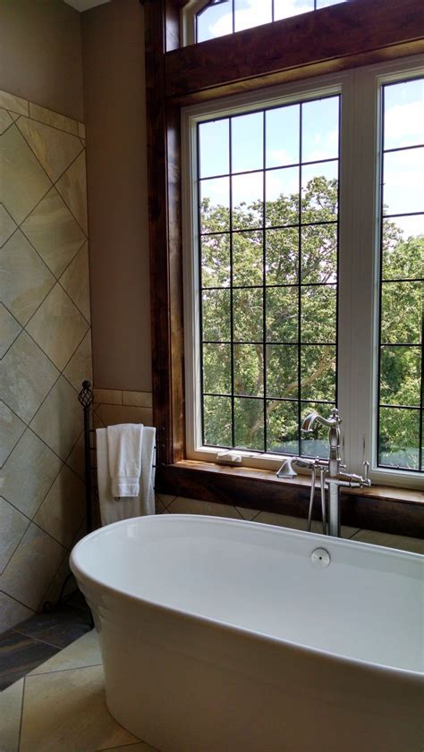 Freestanding Bath Tub With Tall Windows And Custom Grille Pattern