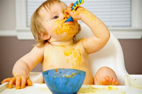 Messy Baby Eating Food In High Chair Stock Photo Download Image Now